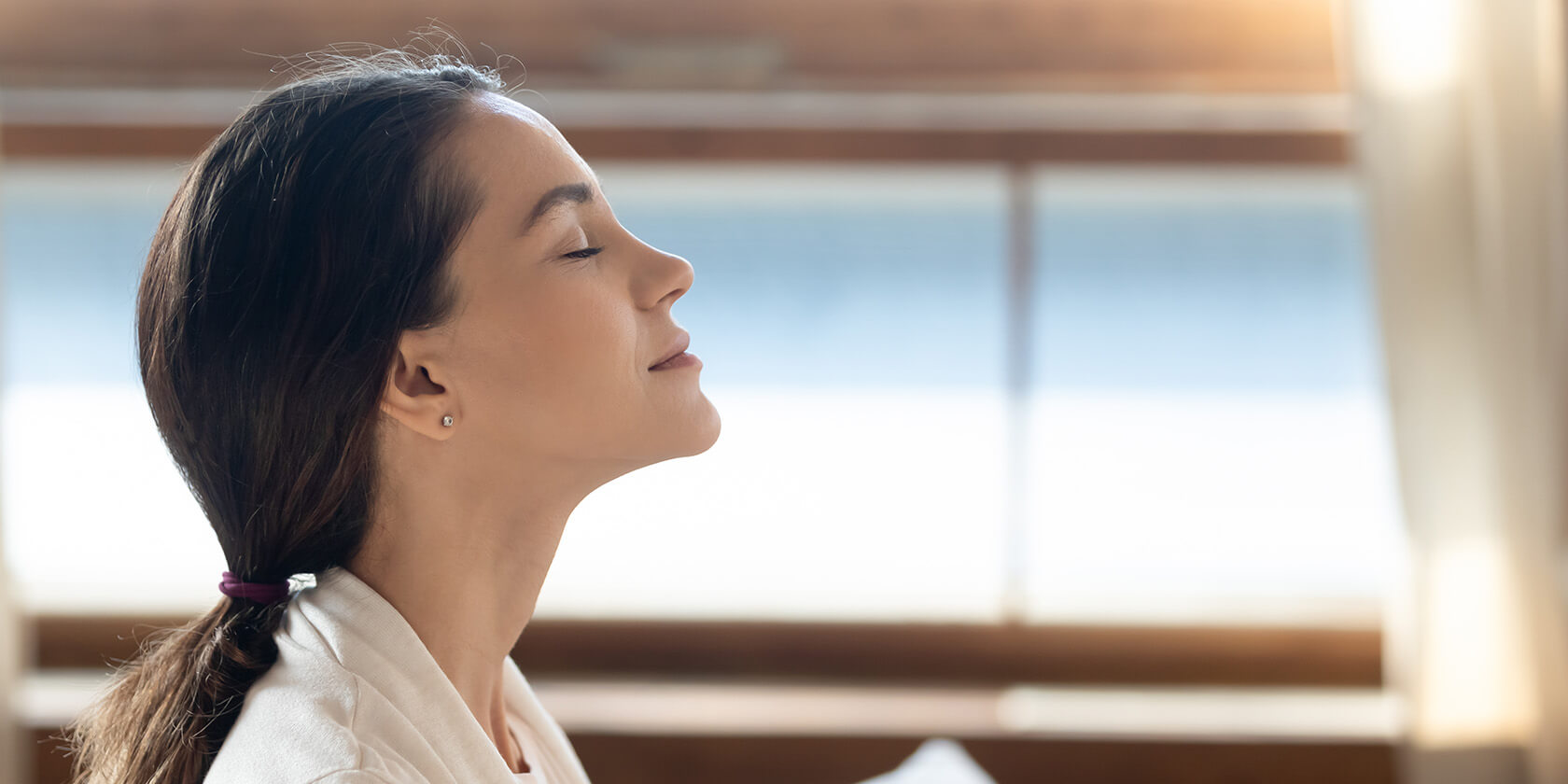 woman sitting peacefully inside meditating breathing easily